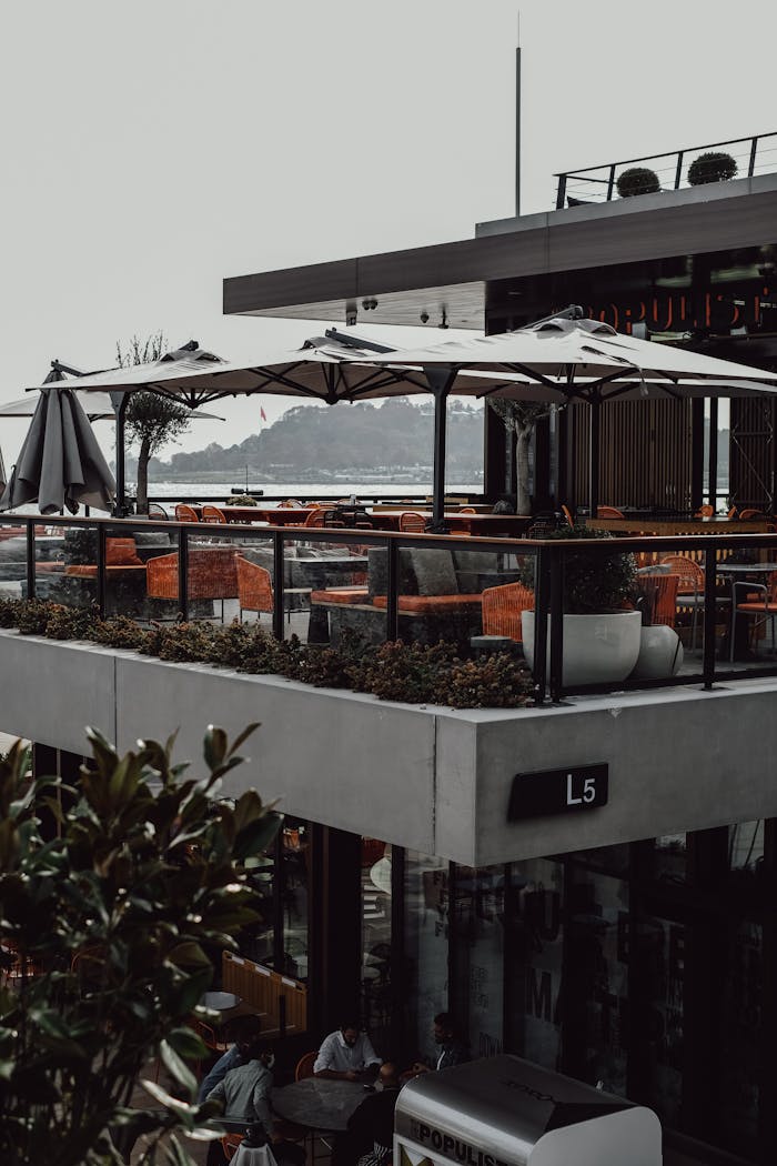 Elegant rooftop dining area with umbrellas overlooking Bosphorus in Istanbul.